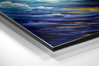 Close-up angled view of brushed aluminum Dibond wall art showing layered blue, white, and golden ocean wave design with black and silver frame edges.