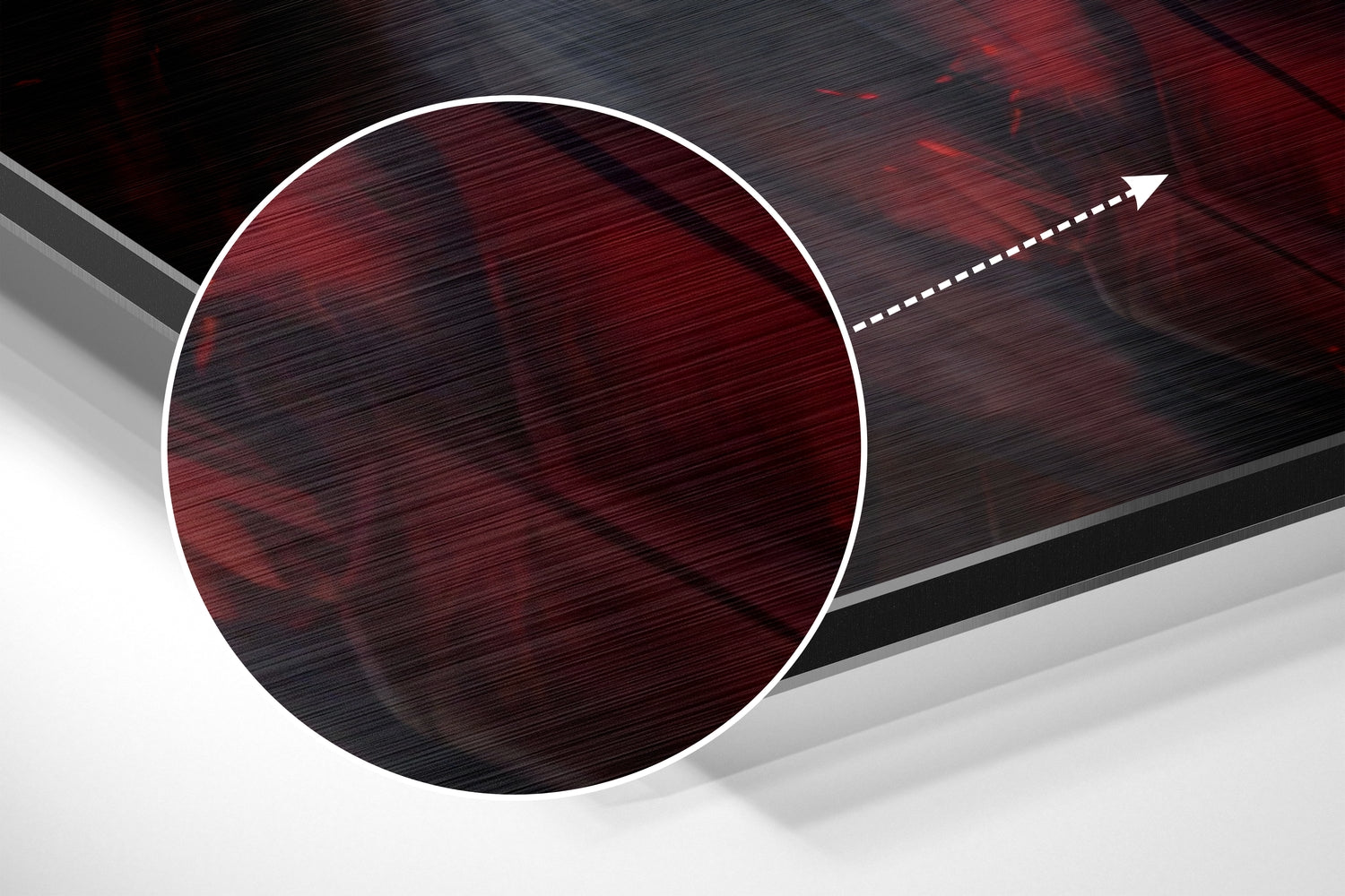 Close-up angled view of brushed red and black aluminum wall art circle with white border and directional arrow detail.