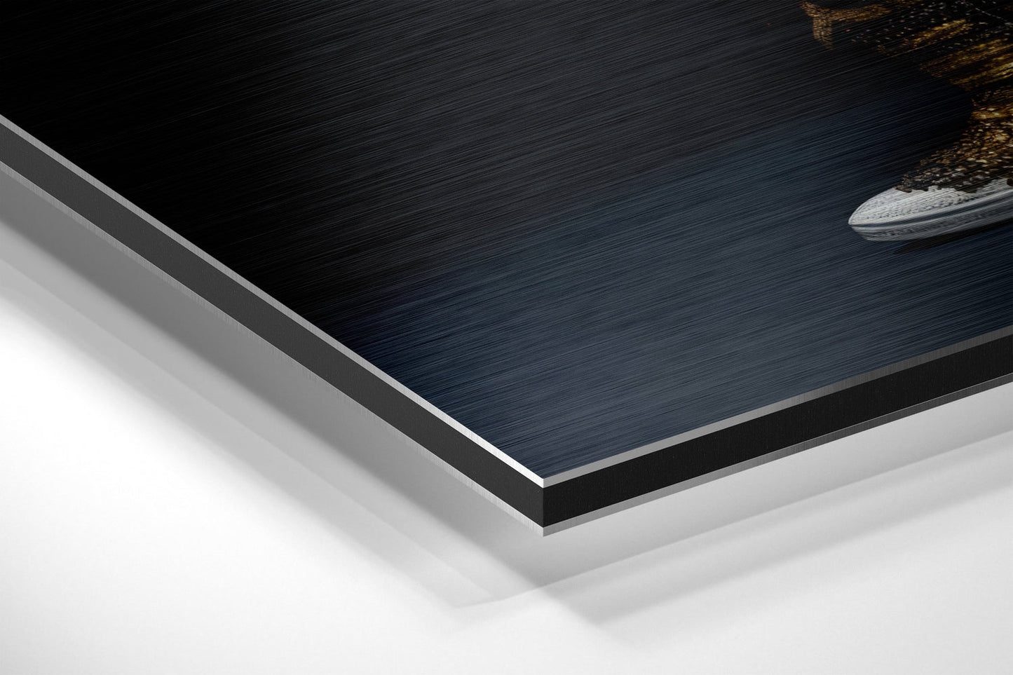 Close-up angled view of layered Dibond panel showing brushed dark blue top surface with silver aluminum edges and white backing layers.
