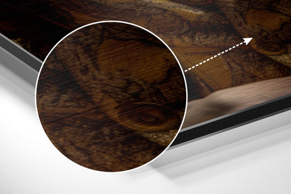 Close-up detail of brushed aluminum Dibond wall art showing dark wood grain texture with white circular outline and directional arrow annotation.