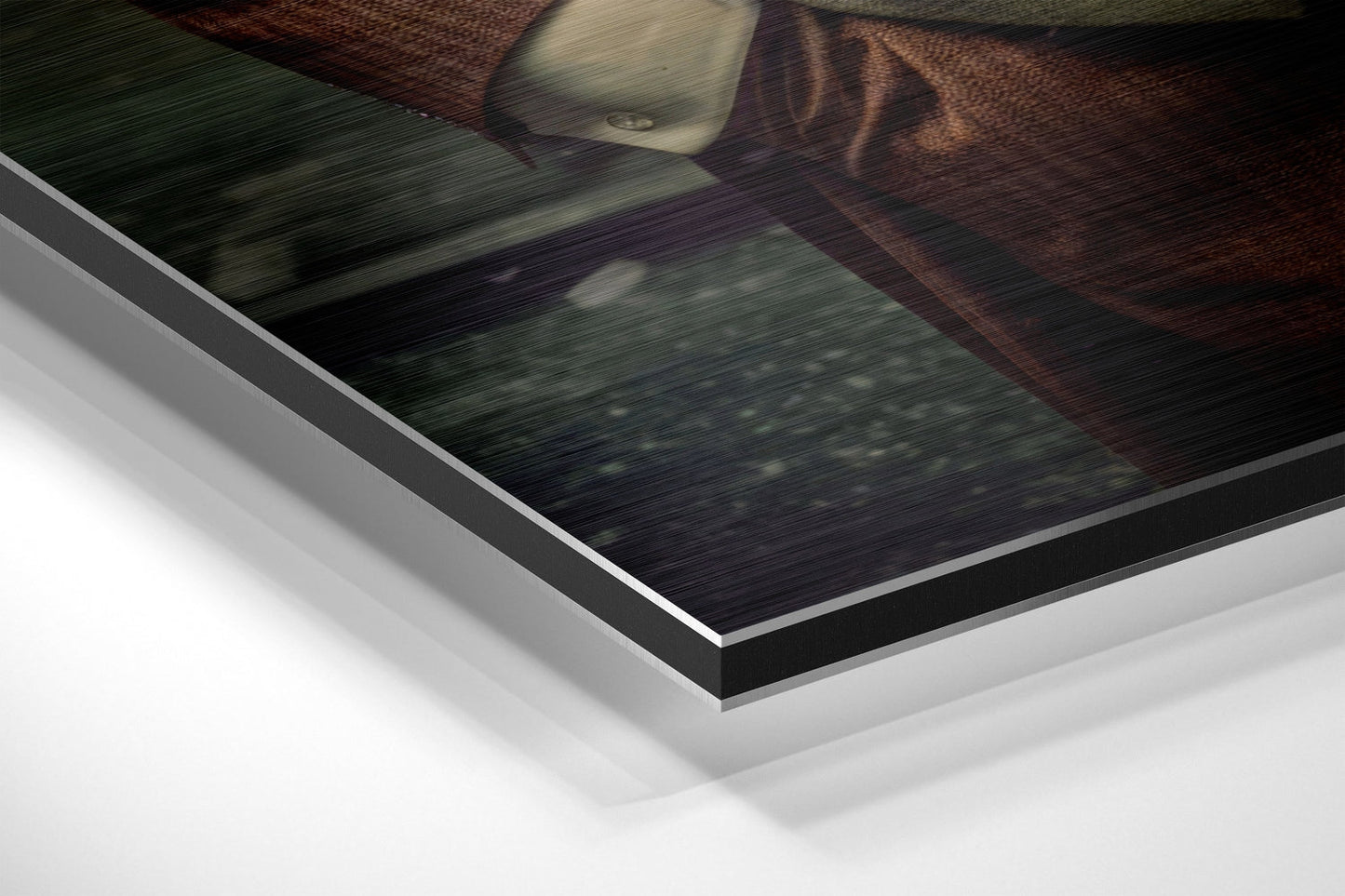 Close-up angled view of layered Dibond wall art showing white backing, black edge trim, and brushed aluminum surface with textured fabric detail visible.