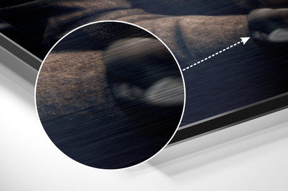 Close-up detail of brushed aluminum surface showing dark wood grain texture and directional arrow, angled perspective view.
