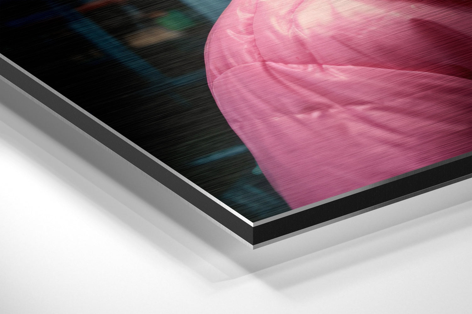 Close-up angled view of brushed aluminum Dibond wall art featuring pink fabric texture with blurred background, showing layered edge construction.