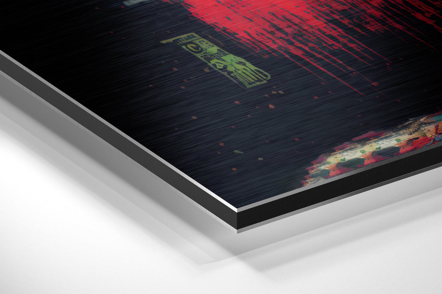 Angled closeup of brushed aluminum Dibond wall art showing layered edge profile with red and black digital design and green text on dark surface.