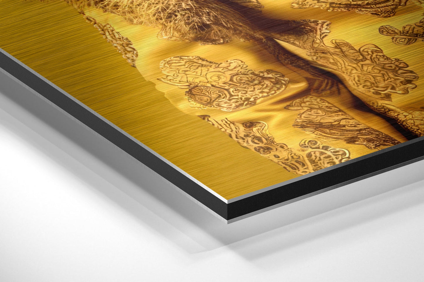Close-up angled view of brushed gold aluminum Dibond wall art showing layered edge construction with black and white core layers visible.