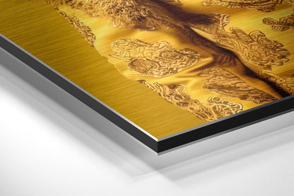Close-up angled view of brushed gold aluminum Dibond wall art showing layered edge construction with black and white core layers visible.