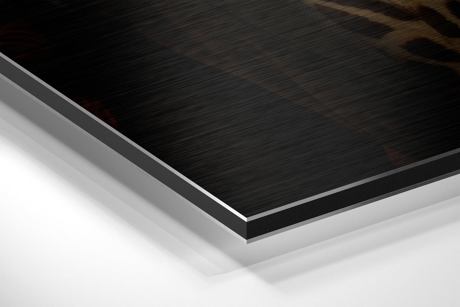 Close-up angled view of layered Dibond panel showing brushed black surface with white aluminum core and backing visible at edge.