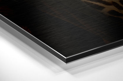 Close-up angled view of layered Dibond panel showing brushed black surface with white aluminum core and backing visible at edge.