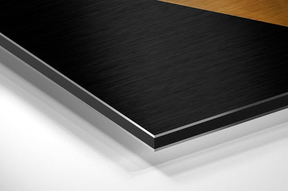 Layered diagonal view of brushed aluminum Dibond panel showing black brushed metal surface with white and gray backing layers and wood edge detail.