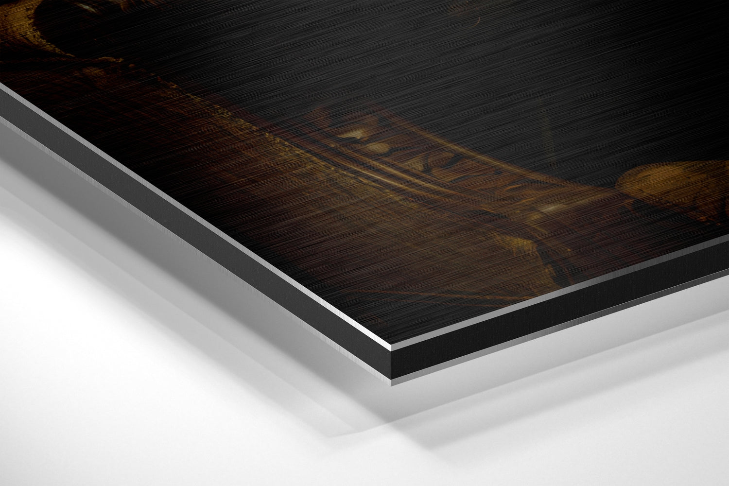 Close-up angled view of brushed aluminum dibond print edge showing layered construction with dark wood-textured top surface and white backing material.