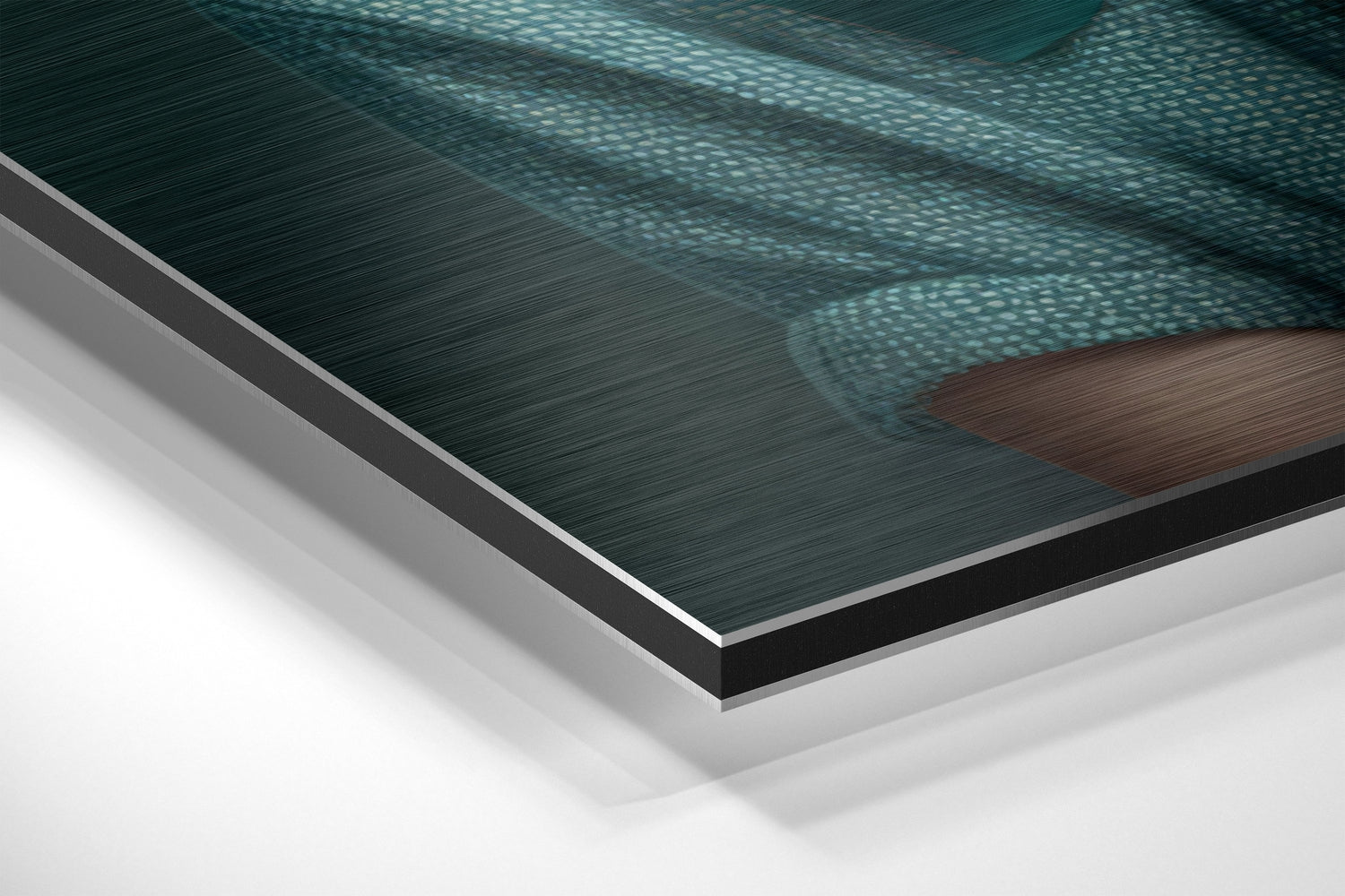 Close-up angled view of layered Dibond panel showing brushed aluminum surface with teal water and brown dog silhouette detail.
