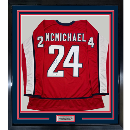 Red Washington Capitals hockey jersey number 24 with McMichael name, signed, framed with blue and red borders and nameplate.
