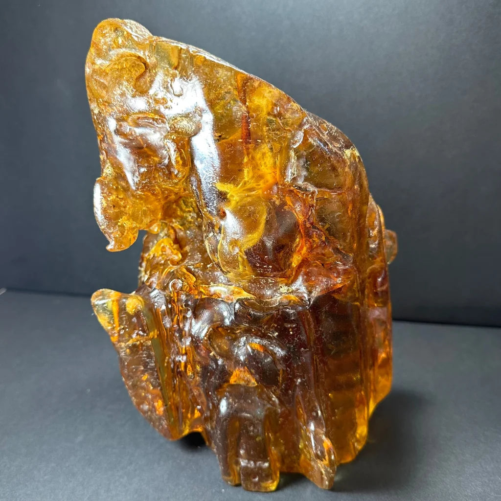 Glossy amber termite hill fossilized resin sculpture with intricate carvings