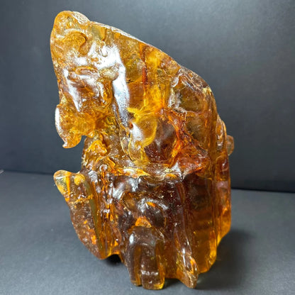 Glossy amber termite hill fossilized resin sculpture with intricate carvings