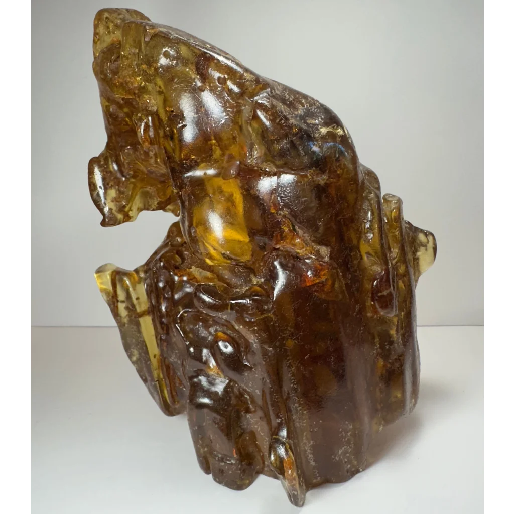 Polished amber termite hill sculpture with golden-brown hue and carvings