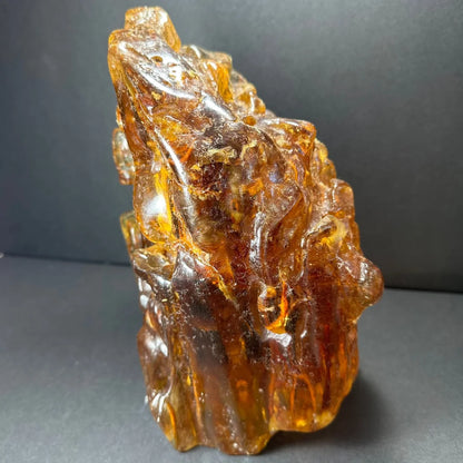 Glossy amber termite hill fossilized resin sculpture with intricate carvings