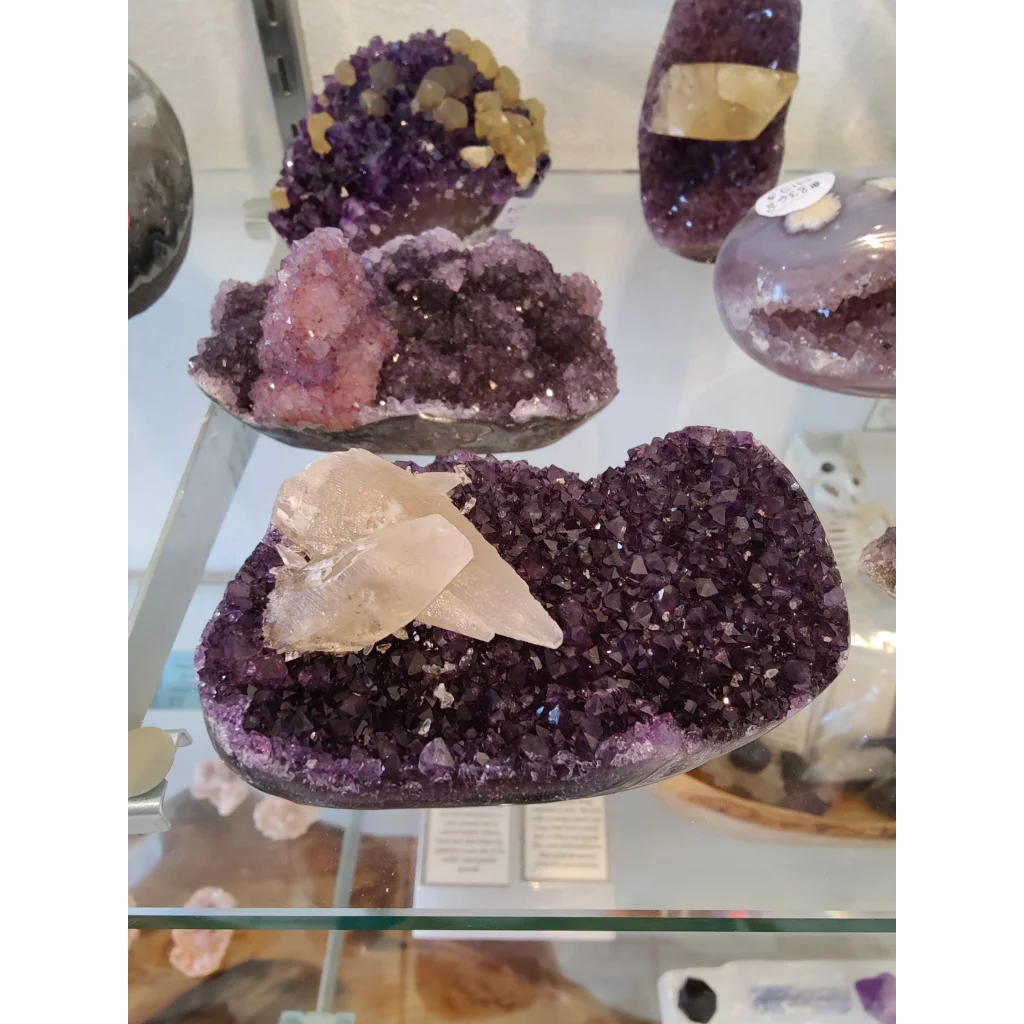 Vibrant purple amethyst geode with calcite crystal inclusions sculpture
