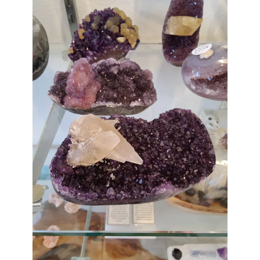 Vibrant purple amethyst geode with calcite crystal inclusions sculpture