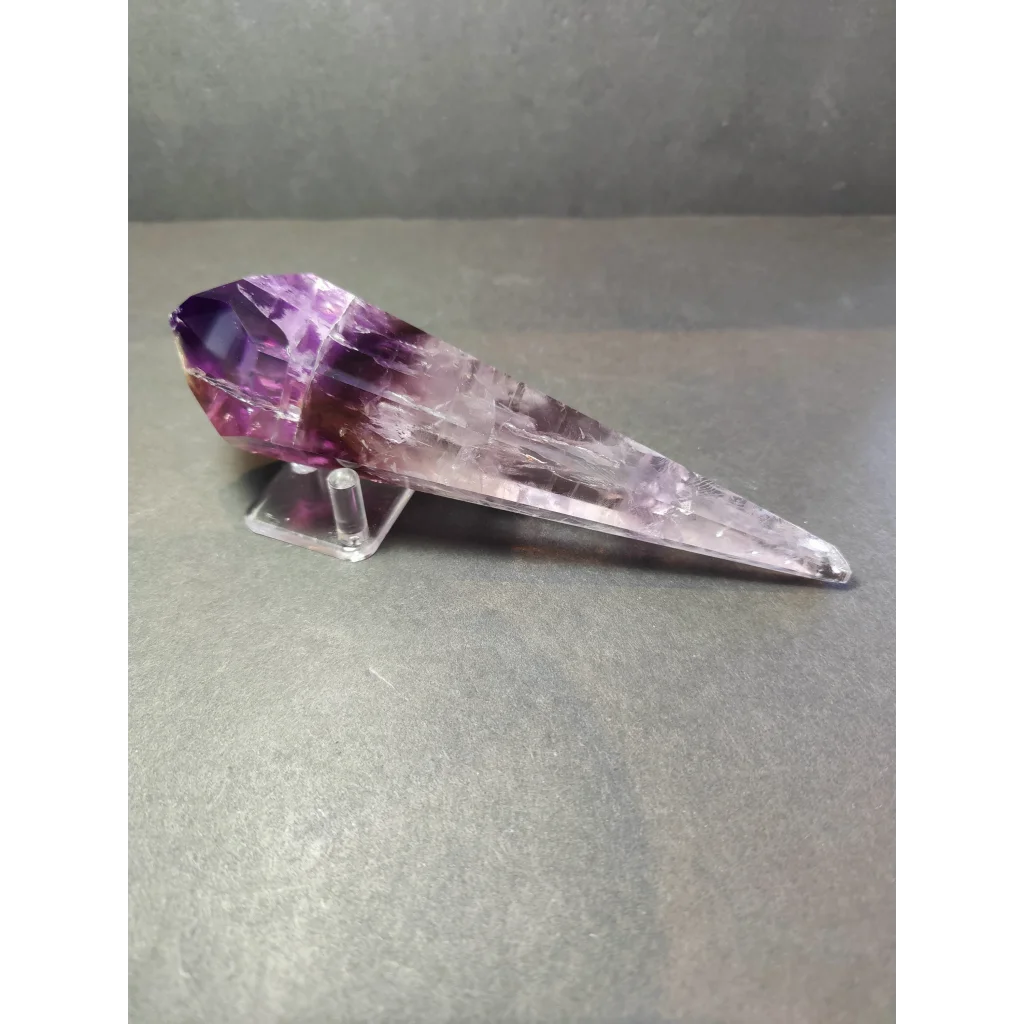 Amethyst polished scepter wand with deep purple to translucent lavender facets and natural mineral inclusions on metal stand