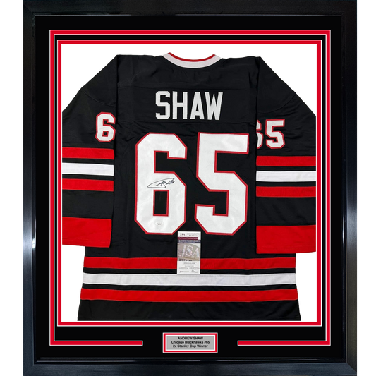 Framed black Chicago Blackhawks jersey number 65 with "SHAW" nameplate, red and white horizontal stripes, signed and authenticated with JSA certificate.