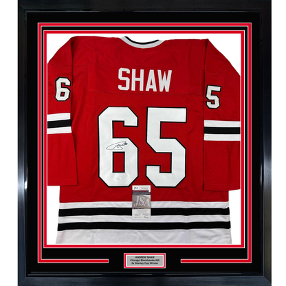Red Chicago Blackhawks jersey #65 with Shaw name and signature displayed in black frame with red and white mat borders.