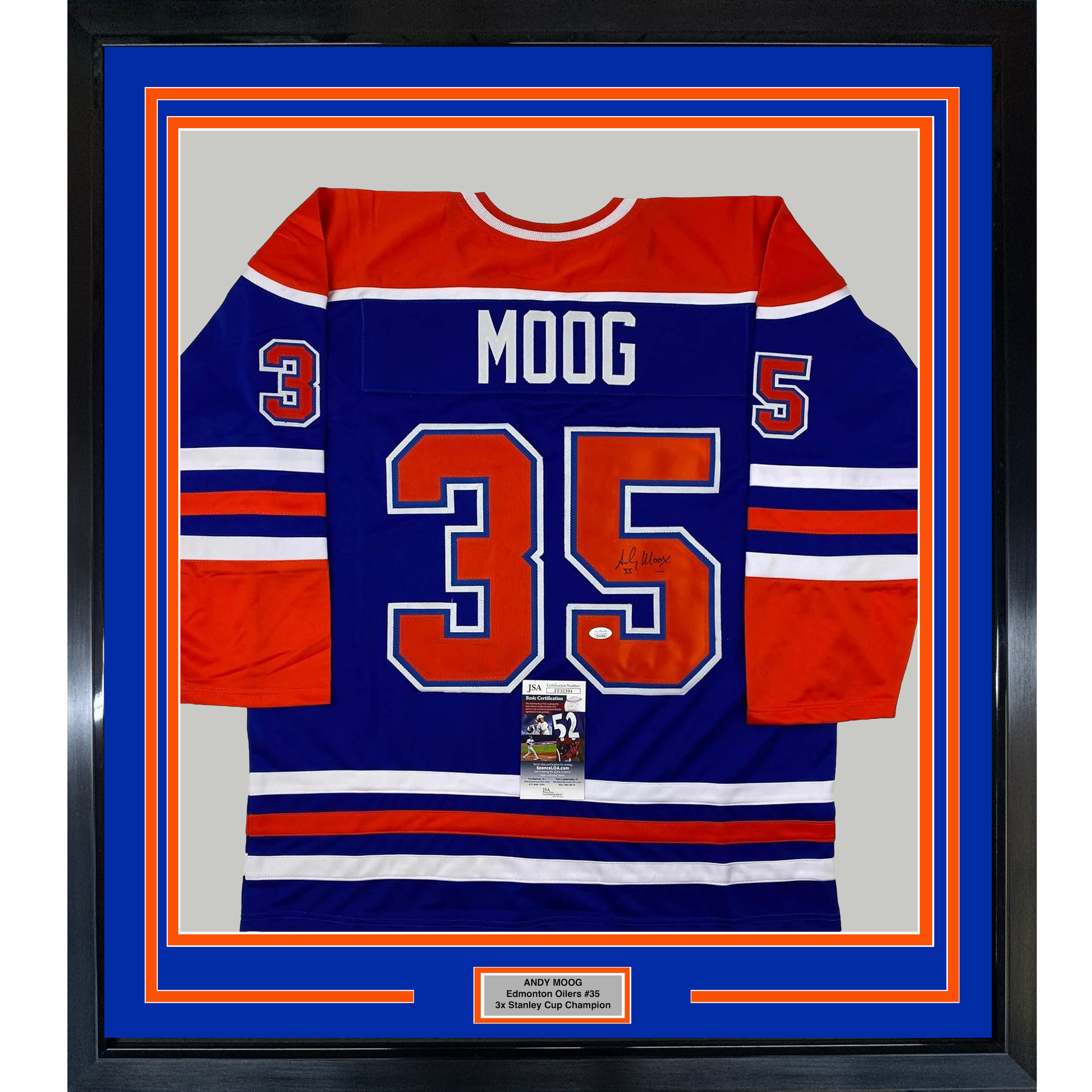 Framed Edmonton Oilers hockey jersey number 35 with "MOOG" nameplate, navy blue and red striped design, displayed front-facing against blue matting with orange border.