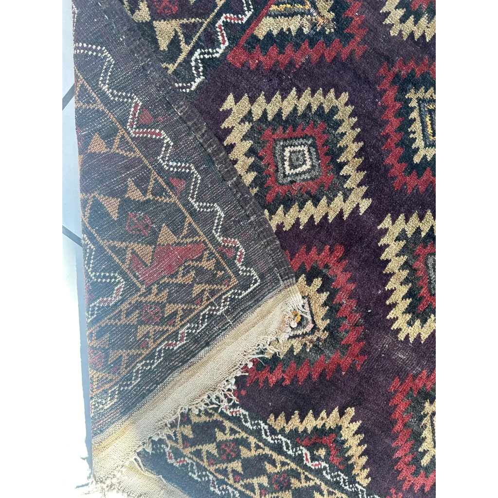 Antique 1900s tribal Baluch wool rug in dark purple with geometric patterns