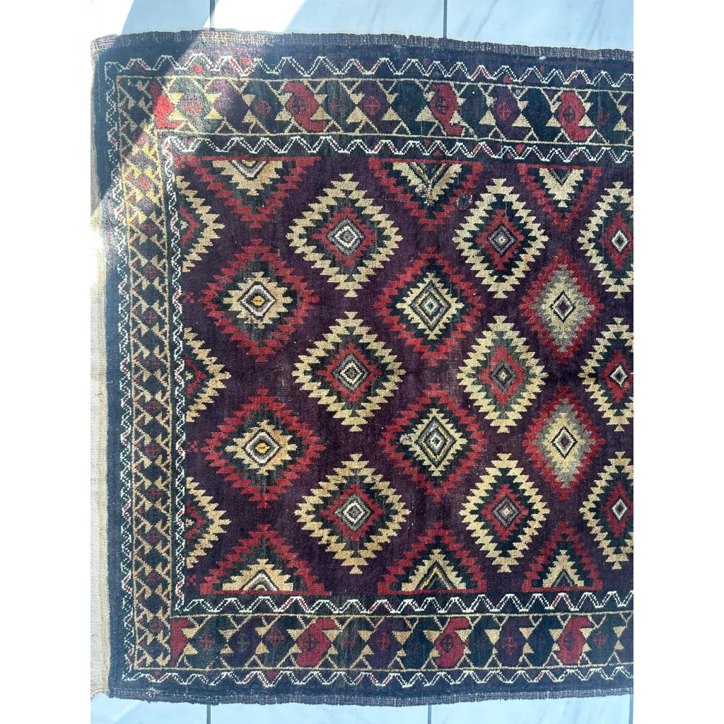 Antique 1900s tribal Baluch wool rug with bold geometric diamonds