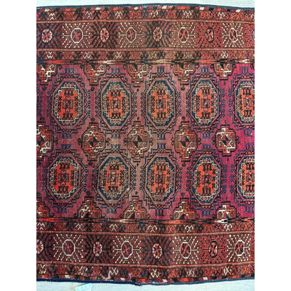 Antique 1910s Turkoman rug with dense geometric patterns in deep red, dark blue and ivory wool pile