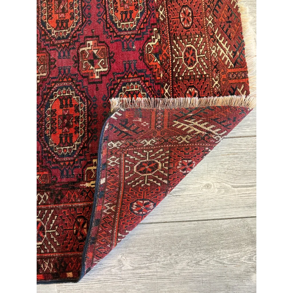 Antique 1910s tribal Turkoman rug in rich crimson red with intricate geometric patterns and ivory accents