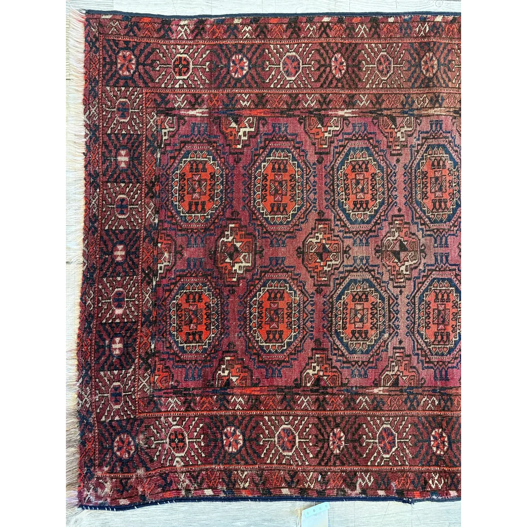Antique 1910s Turkoman rug with geometric angular motifs in deep red, blue and cream natural wool