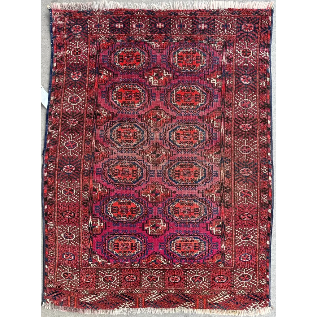 Antique 1910s tribal Turkoman rug in deep red and burgundy with rows of geometric gul medallions