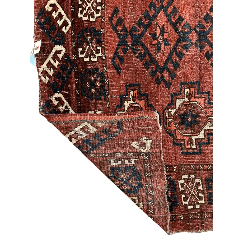 Antique Kizil Ayak Turkoman chuval rug with rust-red base and geometric patterns