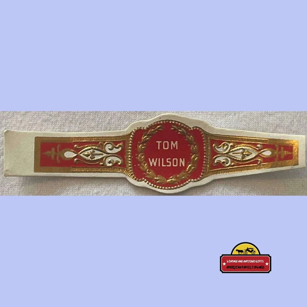 Ornate antique vintage cigar band featuring Tom Wilson in red and gold design