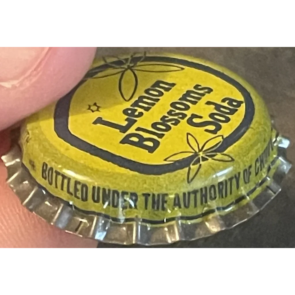 Yellow cork bottle cap from Lemon Blossoms Soda with floral designs and text