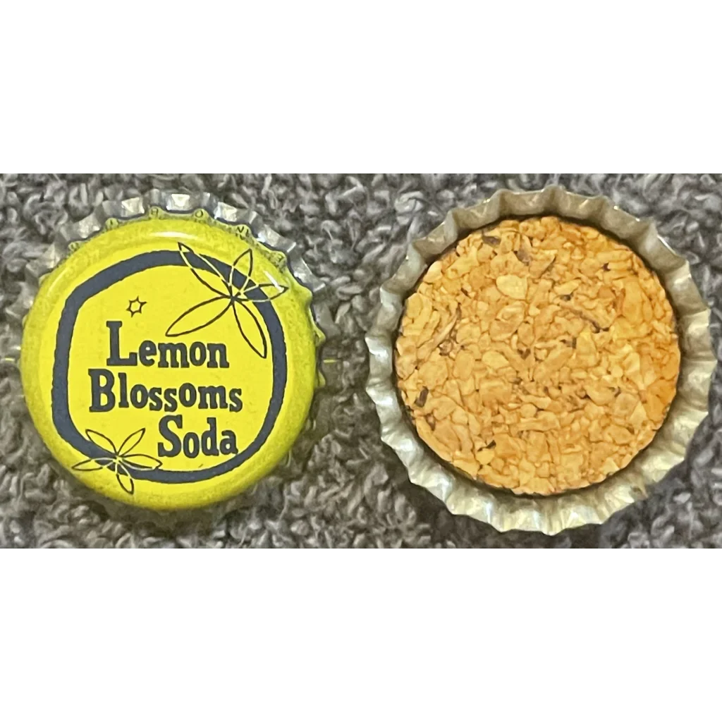 Bottle cap from Lemon Blossoms Soda next to a cork bottle cap filled with yellow stuff