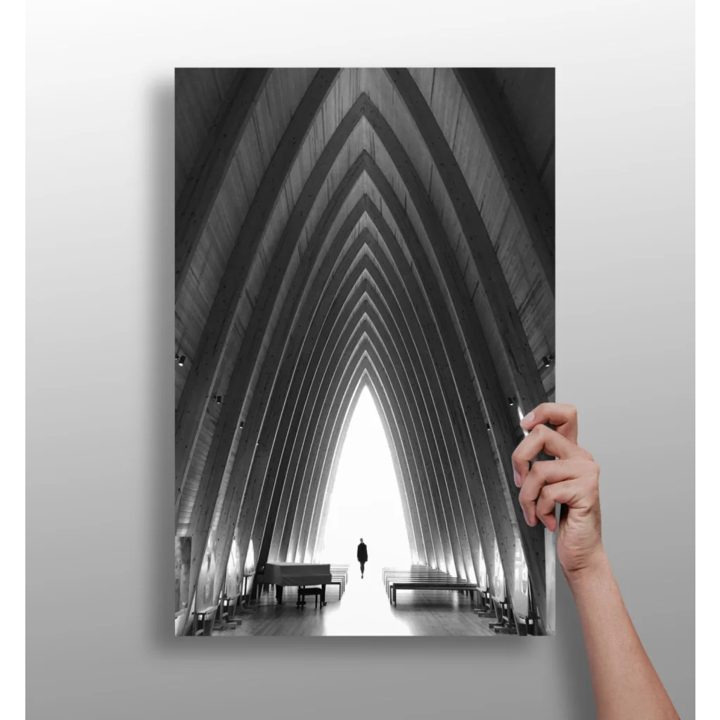 Black-and-white photo of person in arched corridor with distant piano on aluminum print