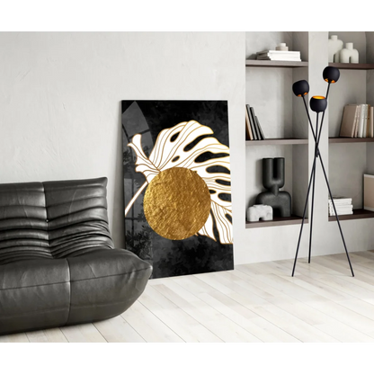 Stylized black and gold monstera leaf glass wall art with textured circle center