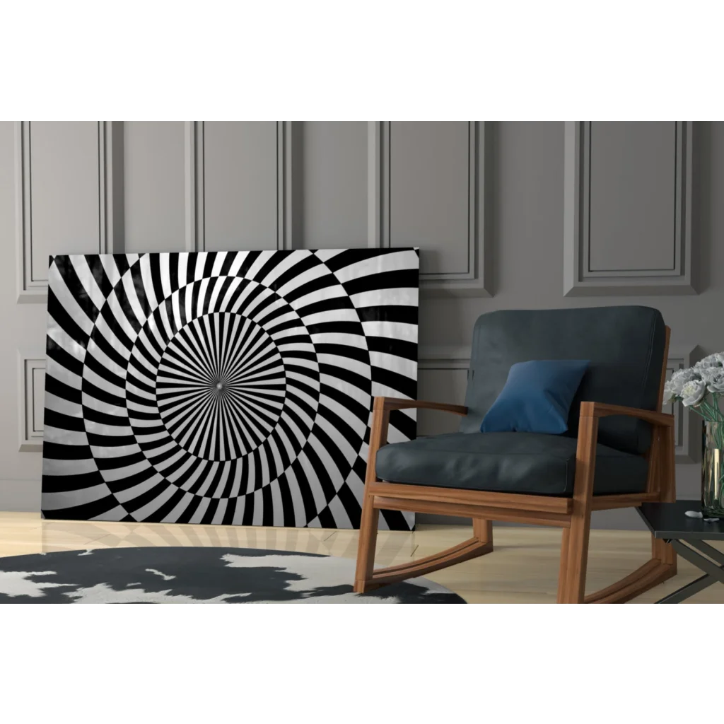 Black and white spiral glass wall art leaning against gray paneled wall
