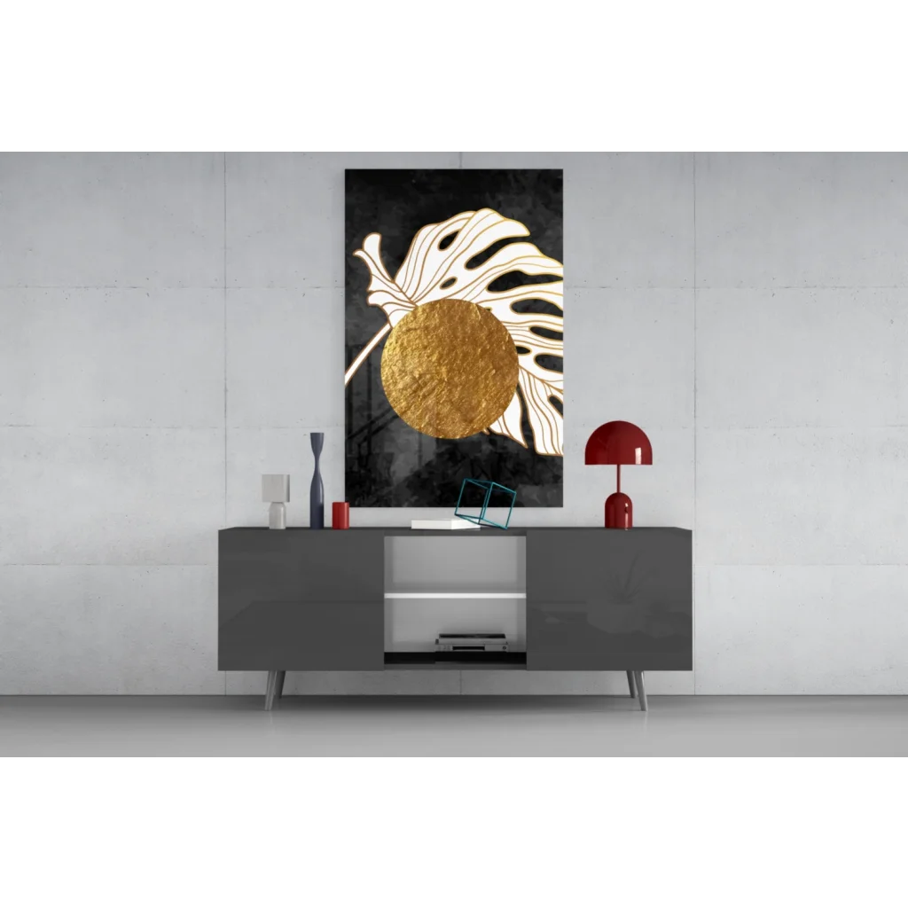 Black and gold glass wall art with textured circle on monstera leaf