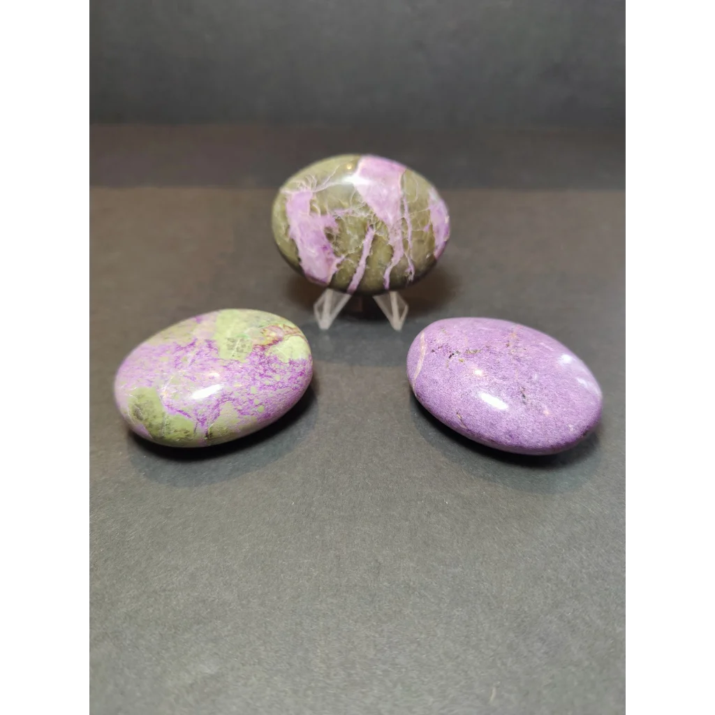 Three polished oval atlantisite stones with vibrant pink purple and green marbled patterns for heart and palmstone use
