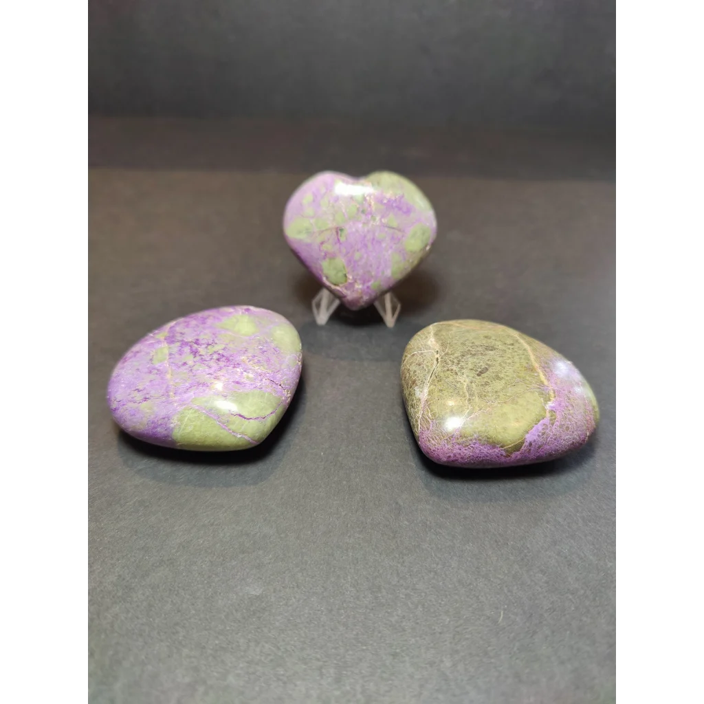 Polished heart and oval jasper stones with marbled purple and green hues in atlantisite palmstone sculpture