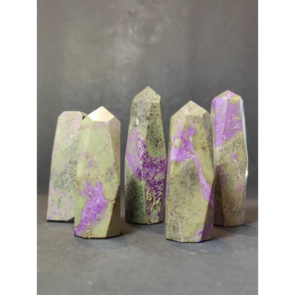 Five polished green and purple atlantisite tower sculptures with natural marbled patterns in a polished tower sculpture set