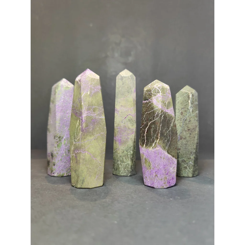 Five polished green and purple atlantisite tower sculptures with natural veining in a polished tower sculpture set