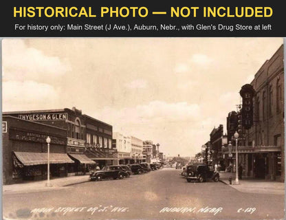 Historical photo, not included: a real-photo postcard of Main Street (J Ave.), Auburn, Nebraska, with the THYGESON & GLEN building and GLENS DRUG STORE sign at left, banded HISTORICAL PHOTO - NOT INCLUDED