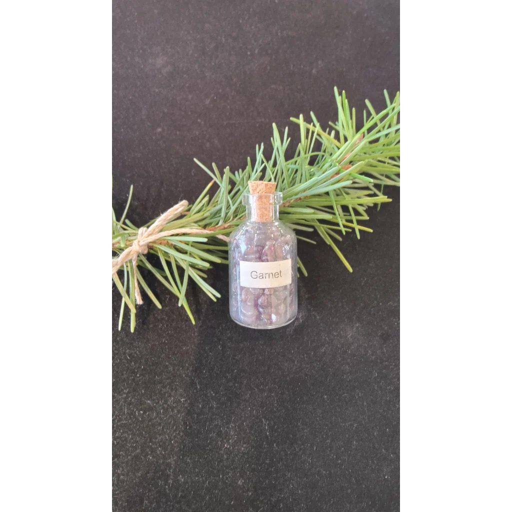Gemstone bottle of dark red garnets in clear glass with cork