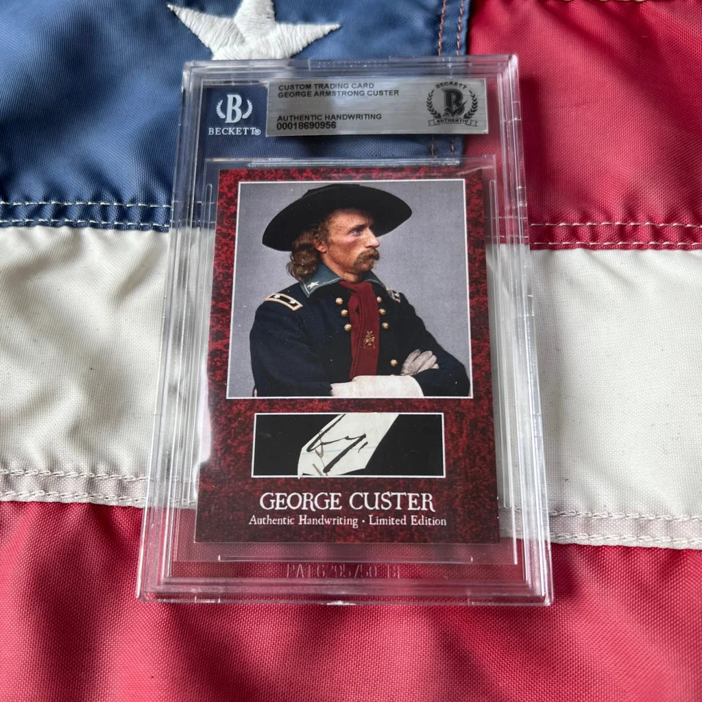 A framed authentic george custer words graded card featuring his handwriting with red textured background and dark uniform