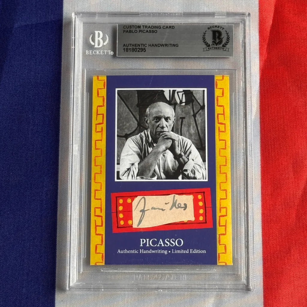 A framed authentic pablo picasso handwriting trading card featuring a black and white portrait with beckett authentication services