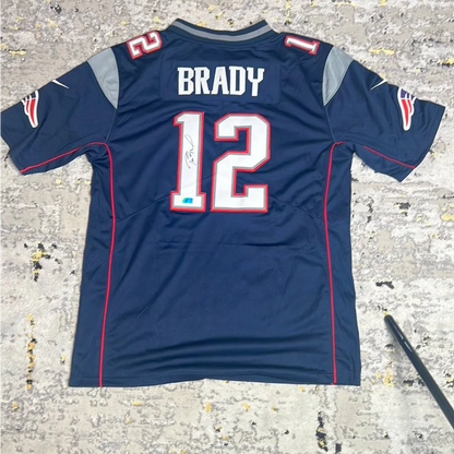 Navy blue New England Patriots jersey with number 12 and Tom Brady signature, official autographed item