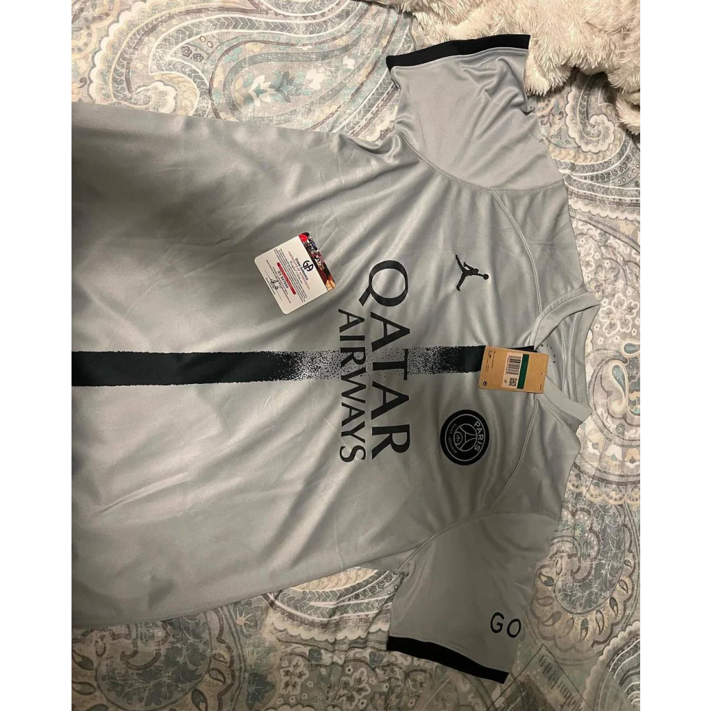 Light gray short-sleeved Kylian Mbappe PSG jersey with dark gray accents, autographed collectible